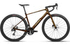 A side-profile view of an Orbea gravel bicycle with a metallic bronze-brown frame, black components, and black tires, set against a plain white background.